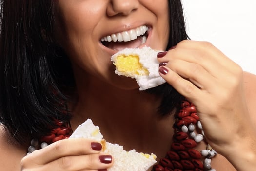 smiling brunette model in Brazilian Indian costume and makeup holding a tapioca, a typical Brazilian snack photo