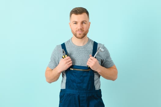 Handsome young craftsman over isolated blue background photo