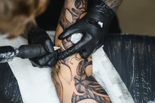 Professional tattoo artist working in his tattoo studio. photo
