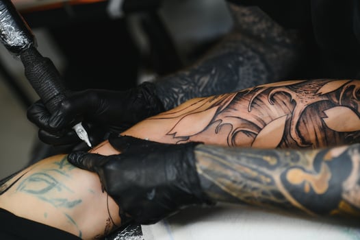 tattooist with his machine tattooing on the arm with the design drawn, concept of art and design photo