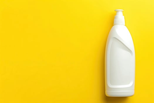 A bottle of liquid soap is on a yellow background photo