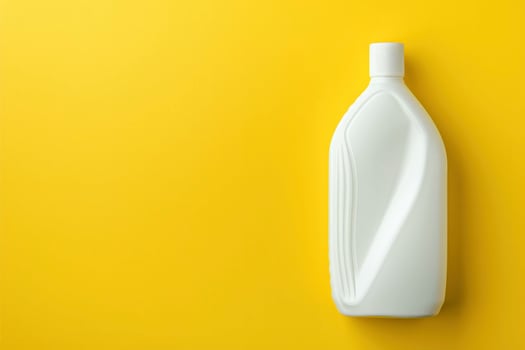 A white plastic bottle on a yellow background photo