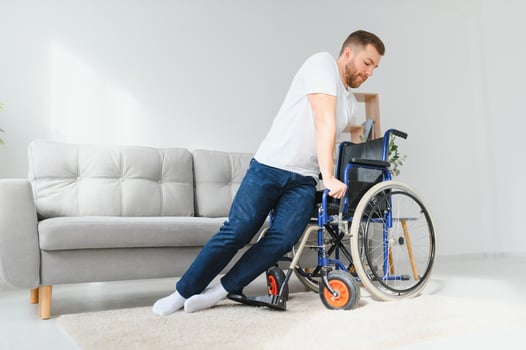 Disabled young black guy trying sit down. photo