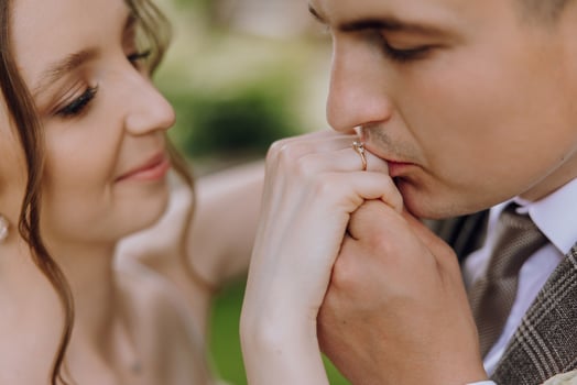 A man and woman are holding hands and the man is wearing a wedding ring photo