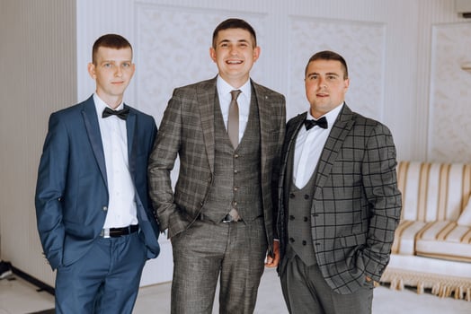 Three men in suits and ties pose for a photo