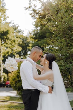 A bride and groom are hugging in a park photo