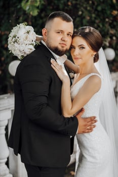 A man and a woman are posing for a picture, the man is wearing a suit photo