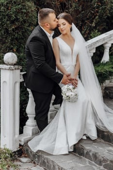 A bride and groom are posing for a picture on a set of stairs photo