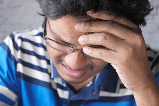 Close up of sad man covering face with hand. photo