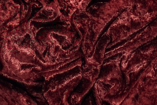 Texture of red velor corduroy fabric with folds photo