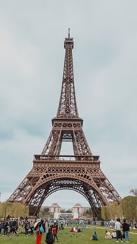 Springtime crowd enjoying a leisurely day under the iconic Eiffel Tower in Paris, France, captured on April 14th, 2024, ideal for travel and culture themes photo