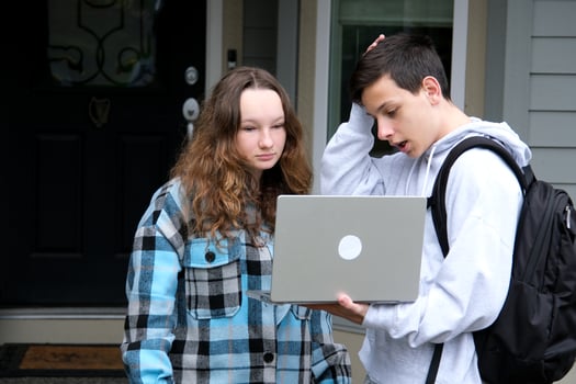 do homework together peep boy and girl sit next in tracksuits and plaid girl smiles turns boy helps finds mistakes straightens hair desire likes help friend School years Classmates teenagers photo