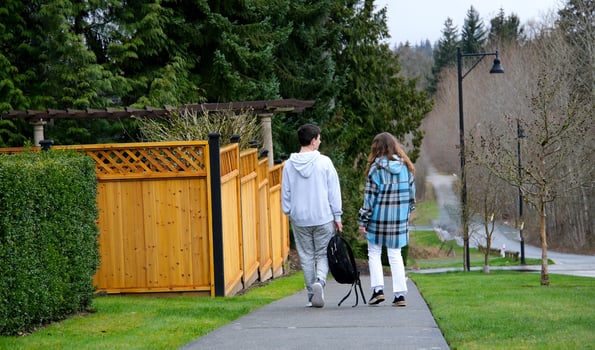 Young man and woman walking together on street in nature on sunny day photo