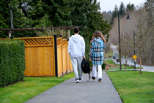 Teen boy and girl back to school in the private sector, two people from school are walking along the sidewalk with a backpack in their hands with their backs to the camera private sector photo