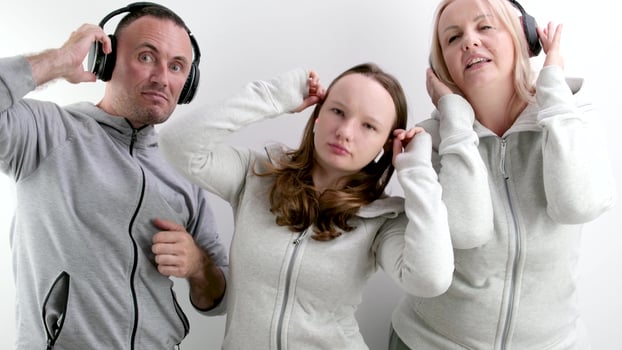 good positive-psychological relations in the family approval teenage girl dancing on a white background in headphones the girl shows the movement of the parents raise their thumbs up they like photo