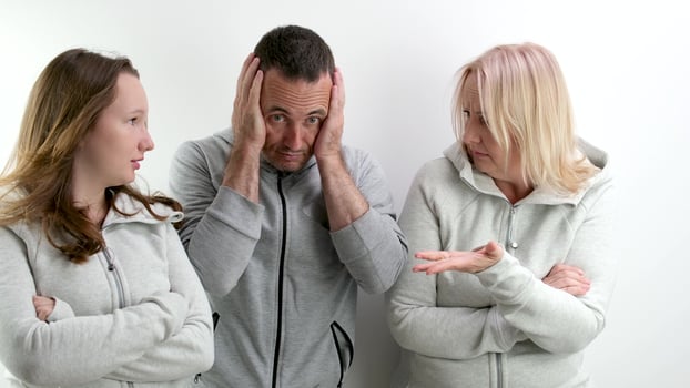 family quarrel women against men two girls mother and daughter scold father wave hands man covers his face in horror bad relationship showdown photo