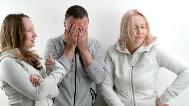 family quarrel women against men two girls mother and daughter scold father wave hands man covers his face in horror bad relationship showdown photo