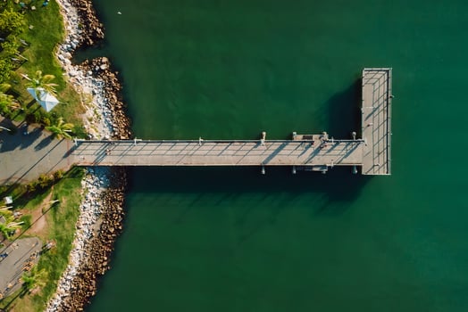Top view of wooden pier and quiet sea with sun light, aerial view photo