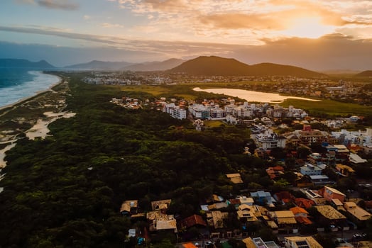 Coastline and town with warm sunset sky in Campeche, Florianopolis. Aerial view photo