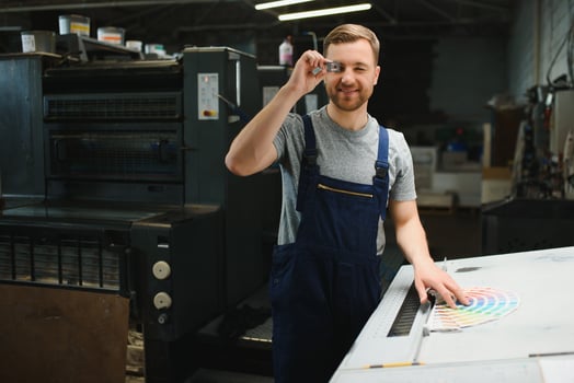 Funny portrait of typographer standing with color swatches at the printing manufacturing photo