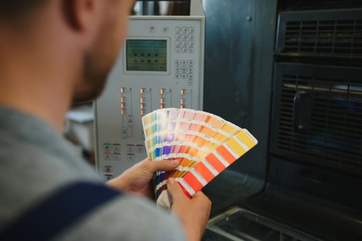 Funny portrait of typographer standing with color swatches at the printing manufacturing photo