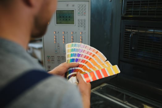 Portrait of production line worker controlling manufacturing process of modern packaging industrial machine in printing factory photo