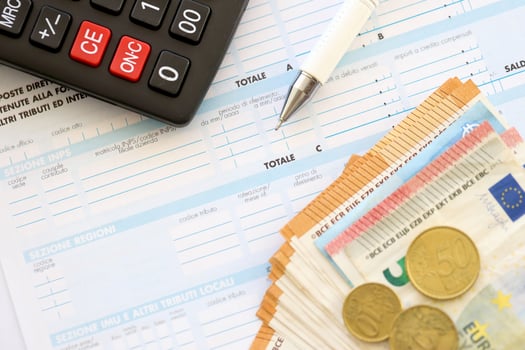 Filling italian tax form process with pen, calculator and euro money bills close up. Tax paying period photo
