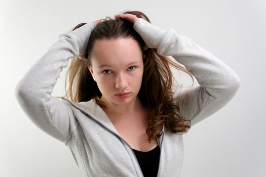 well-groomed brown hair beautiful young girl adolescence waving her head slow motion on a white background studio adjust her jacket lean to the side smile tenderness beauty photo