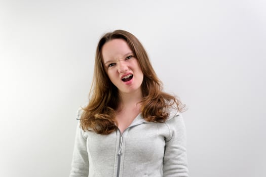 Young caucasian girl screaming into the camera. Slow motion photo