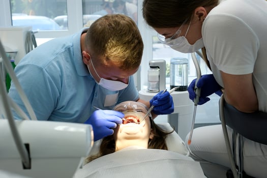 latest technology cleaning and whitening teeth nurse and doctor treating teeth of female patient teenager. latest device in a dental office in a clinic taking care of teeth snow-white smile photo