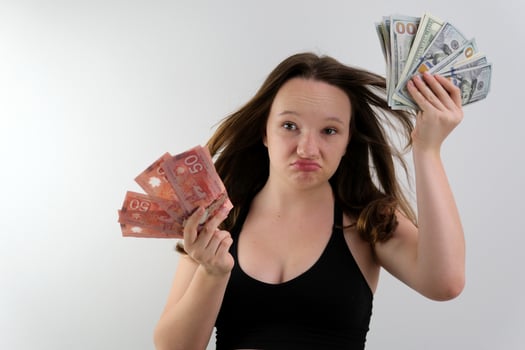 teenage girl angrily waving 100 dollar bills at the camera surprised makes faces opens her mouth attitude to money incomprehensible situation golden youth canadian dollars photo