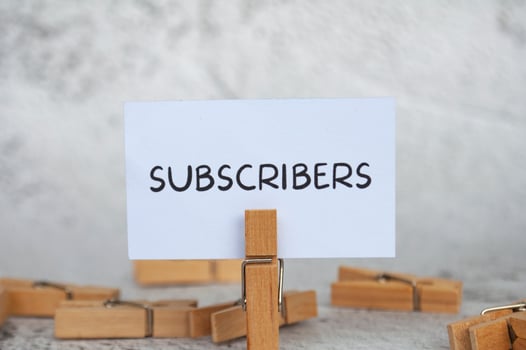 Subscribers text on standing yellow paper. Lead generation concept. photo