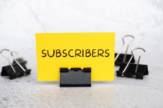 Subscribers text on standing yellow paper. Lead generation concept. photo