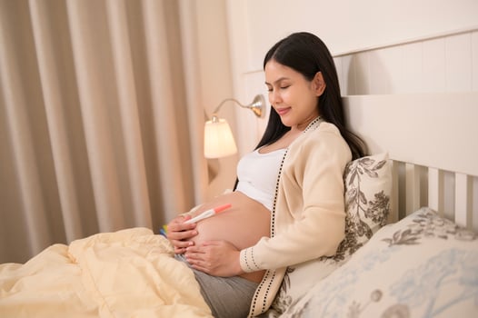 Beautiful pregnant woman holding positive pregnancy test, fertility infertility treatment, IVF, future maternity concept photo