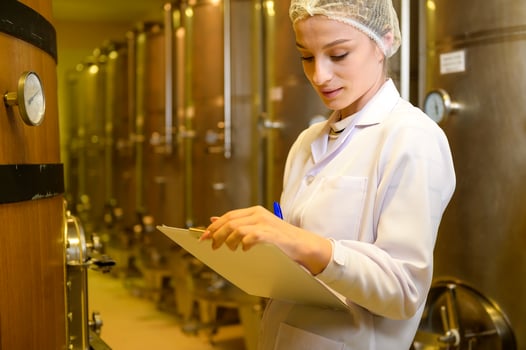 Professional winemaker controlling wine making process and quality at winery factory photo