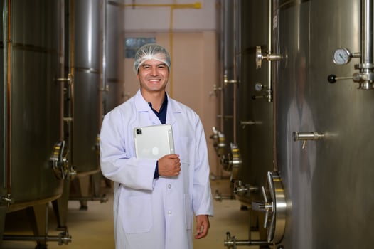 Professional winemaker controlling wine making process and quality at winery factory photo