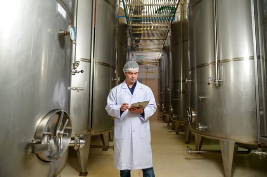 Professional winemaker controlling wine making process and quality at winery factory photo
