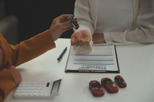 Insurance officers hand over the car keys after the tenant. have signed an auto insurance document or a lease or agreement document Buying or selling a new or used car with a car photo