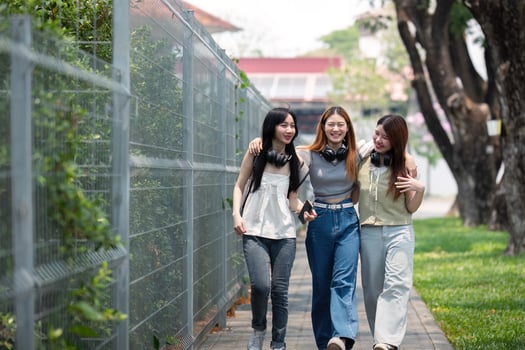 College friends walk to class together. University student in campus talk and have fun outdoors photo