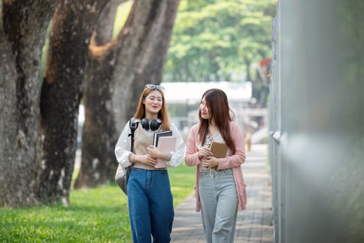 University student girl friends with learning book college while walking in campus photo