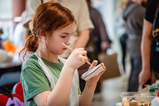 cute teen girl at a master class making a craft from wood, exhibition of crafts, crafts fair, education, master classes photo