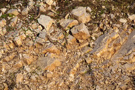 Red rocks of different shapes and sizes on the ground. Orange texture. Background. For text. For banner. Horizontal photo