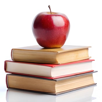 an apple sits on top of three books photo