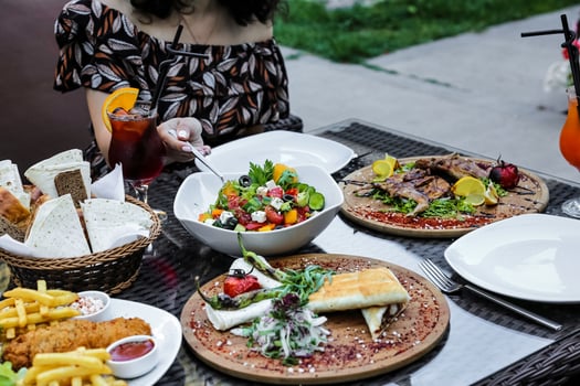 Woman Sitting at Table With Various Plates of Food photo