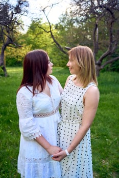 a mother and her teenage daughter are hugging and playing in the garden photo