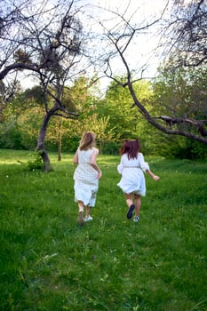 a mother and her teenage daughter are hugging and playing in the garden photo