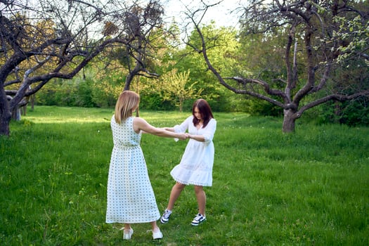 a mother and her teenage daughter are hugging and playing in the garden photo