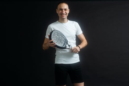 Padel Tennis Player with Racket in Hands. Paddle tennis, on a black background. photo