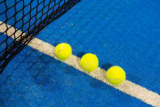 paddle tennis racket and balls on the blue paddle court photo