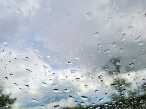 View from wet car window on rainy spring clouds photo